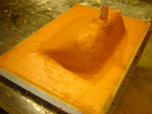 underside of orange integral concrete sink in mold cast with stiff mix