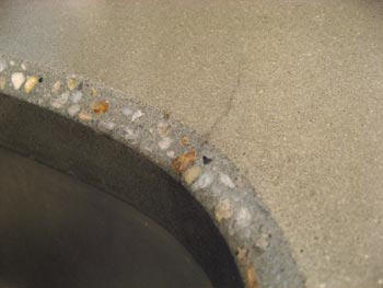 hairline crack by sink in concrete countertop