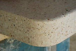 closeup of corner of tan concrete countertop with small decorative stone aggregate