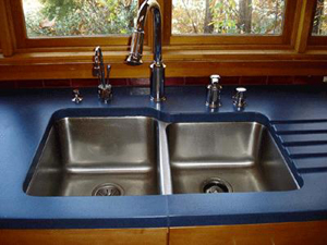 blue concrete countertop with undermount sink and custom drainboard grooves