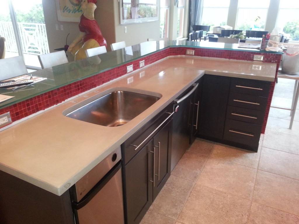 white concrete countertop in kitchen with red glass backsplash tiles
