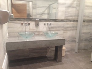 thick gray concrete sink vanity with two glass vessel sinks