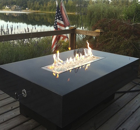 rectangular concrete fire pit by lake with American flag