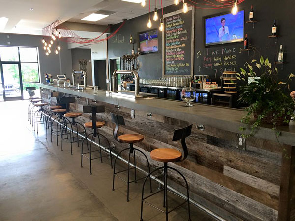 gray concrete bartop in brewery with reclaimed wood panels