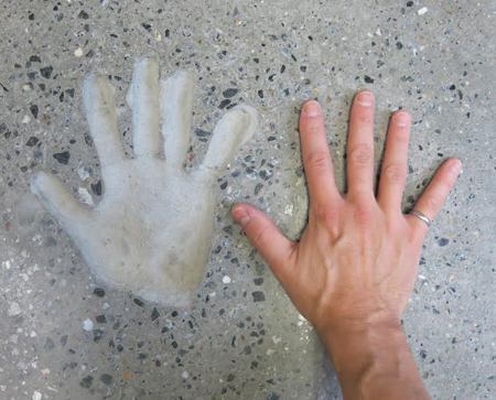 handprint cast in concrete table top with man's hand showing Order of the Engineer steel ring