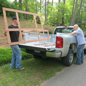 men loading wooden concrete countertop template into truck