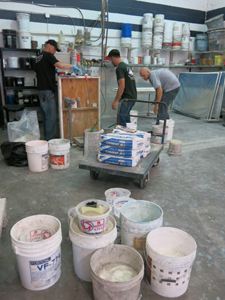 three men measuring concrete countertop mix ingredients