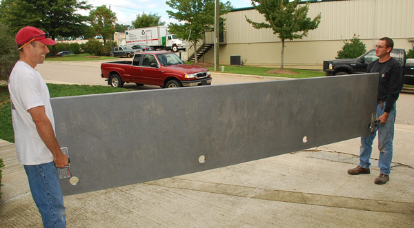 two men lifting lightweight concrete desk made from GFRC