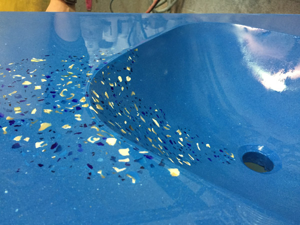 closeup of bright blue concrete sink with glass and mother of pearl embedded