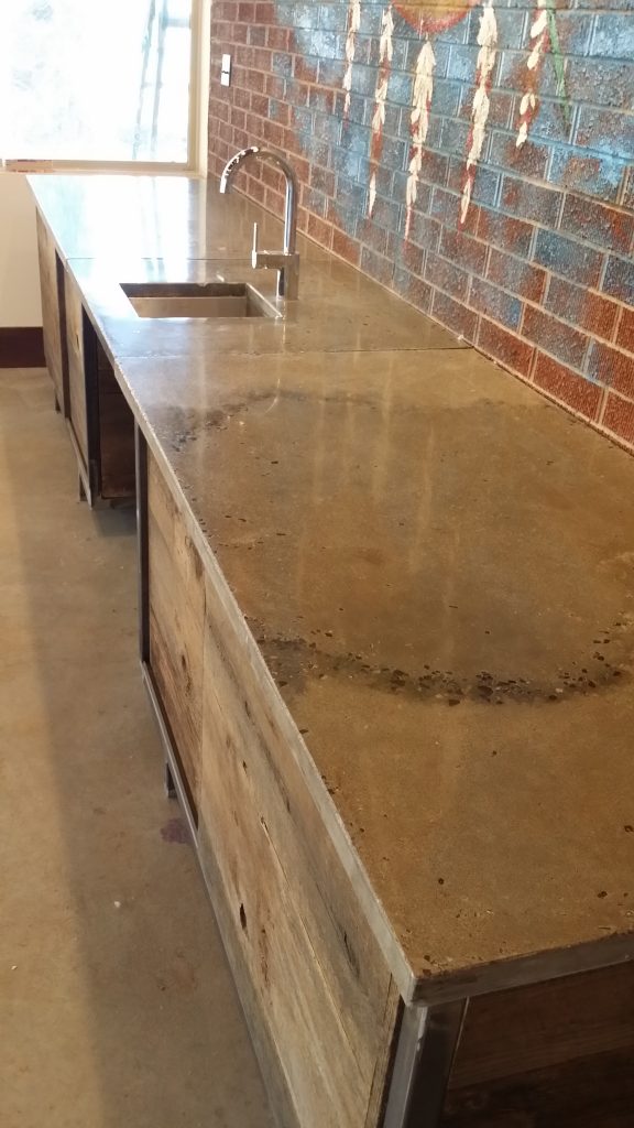 rustic concrete countertop with brick wall